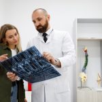 Doctor orthopedist or traumatologist shows tomographic picture to his patient