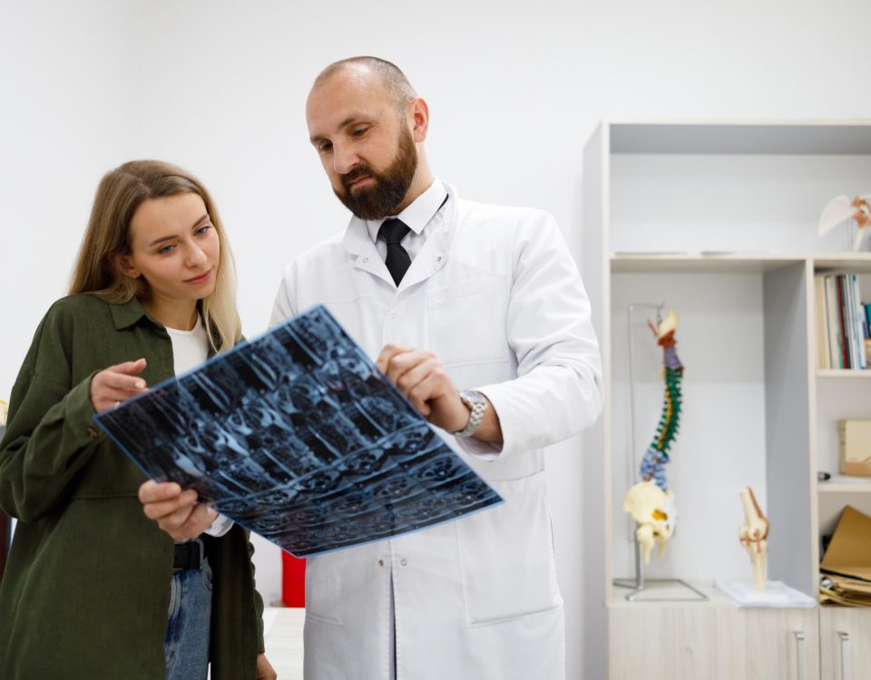 Doctor orthopedist or traumatologist shows tomographic picture to his patient