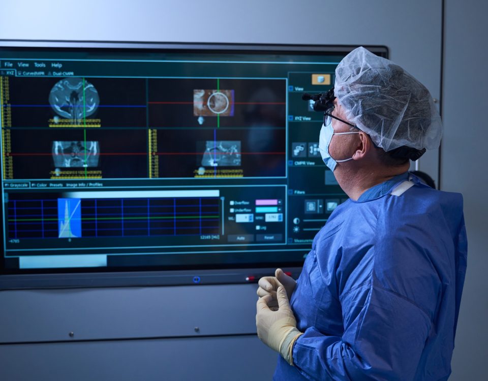 Redéfinir les standards de la chirurgie du dos 4 Surgeon reviewing patient data on OR monitor