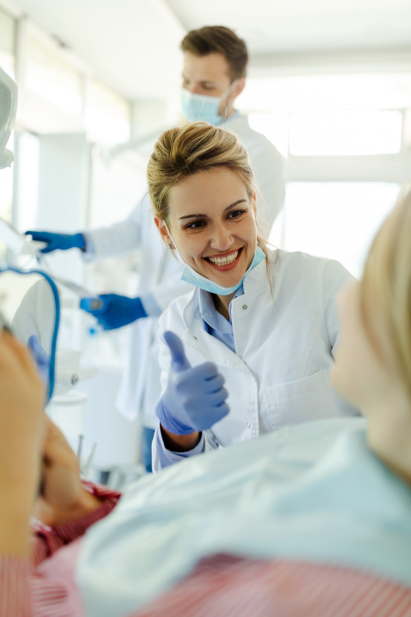 The dentist showing thumb up after the dental treatment as a sign that everything went well.