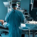 back view of surgeon operating patient in operating room