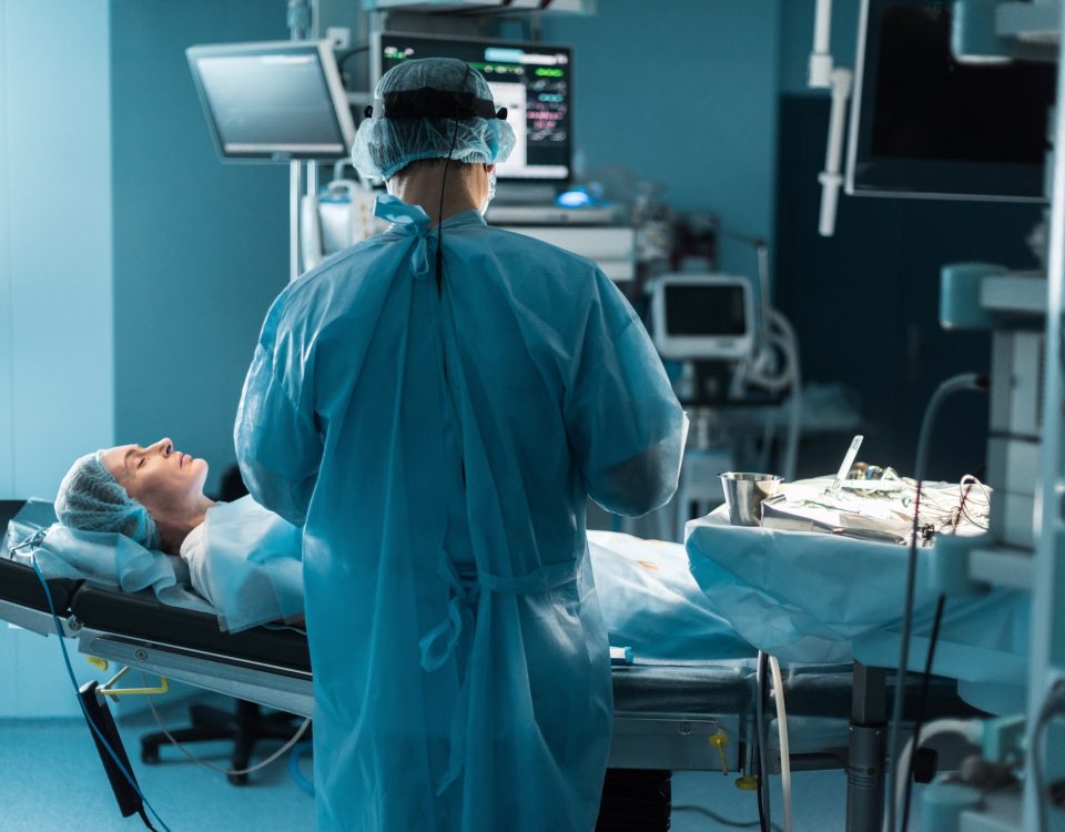 back view of surgeon operating patient in operating room