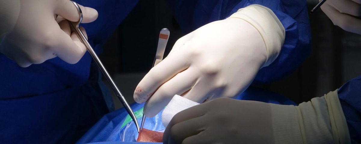 surgeons performing spinal surgery in operating room