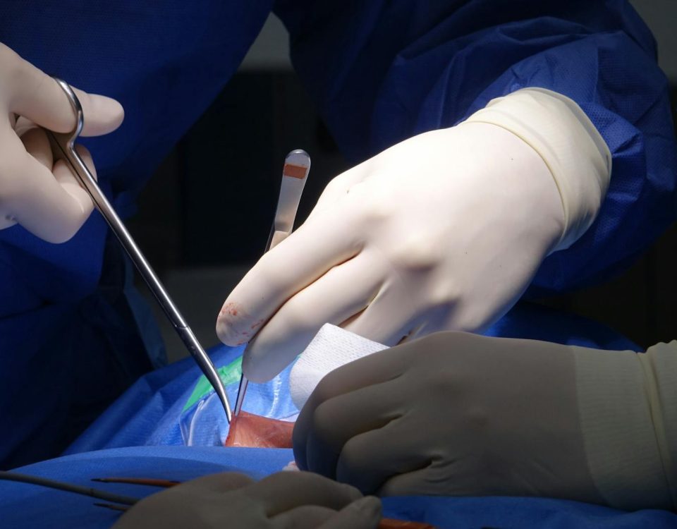 surgeons performing spinal surgery in operating room