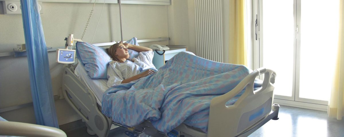 photo of woman lying in hospital bed