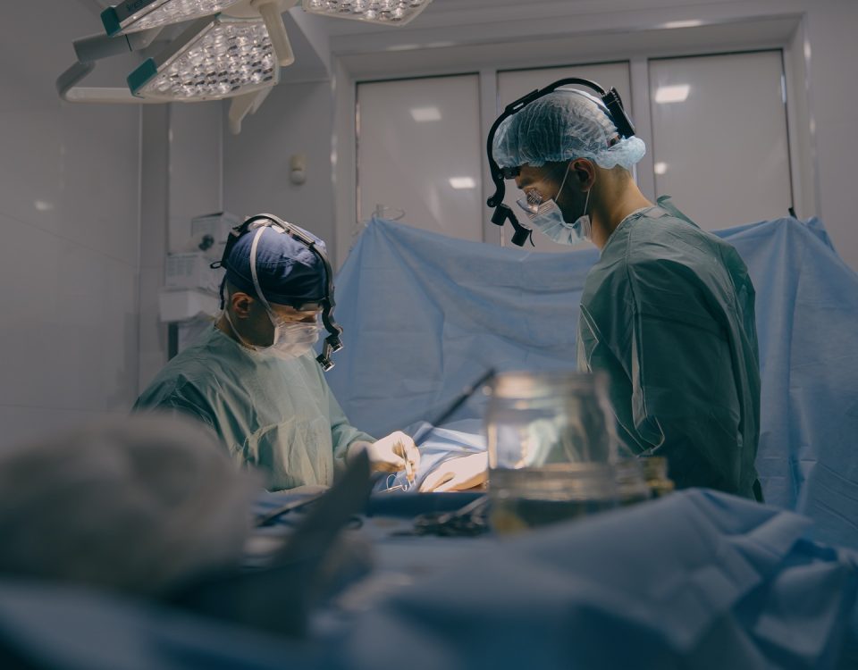 Team of two doctors men surgeons processing surgical operation using endoscopic medical instruments